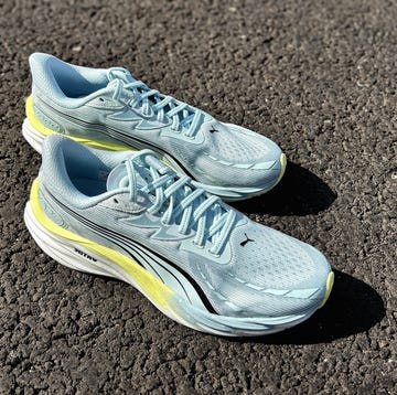 a pair of light blue running shoes with a hint of yellow on a pavement a pair of light blue running shoes with a hint of yellow on a pavement