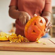 carving jack o lantern out of ripe orange pumpkin