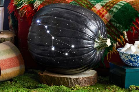 large pumpkin painted black with the big dipper constellation drilled into its rind and illuminated from inside