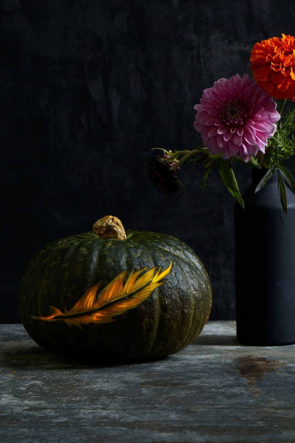 pumpkin carving ideas, dark pumpkin with a feather carving in the center