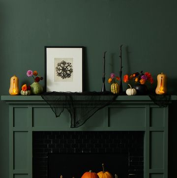 pumpkin carving ideas, pumpkins with carved flam designs in front of the green fireplace