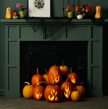 pumpkin carving ideas, pumpkins with carved flam designs in front of the green fireplace