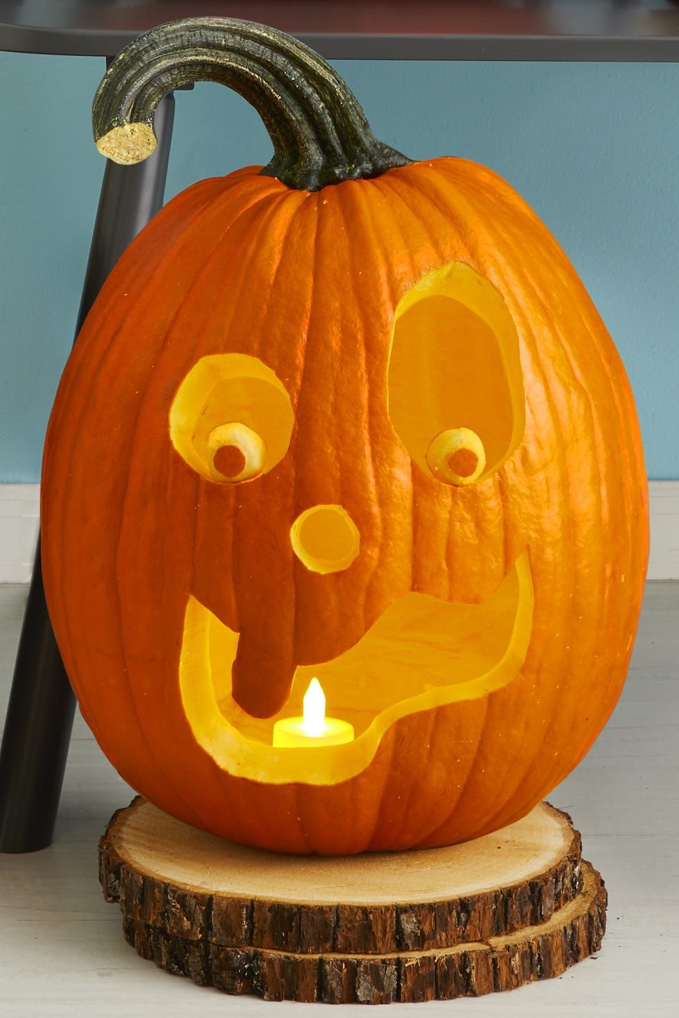 pumpkin carving ideas, carved pumpkin with wide eyes and a goofy grin