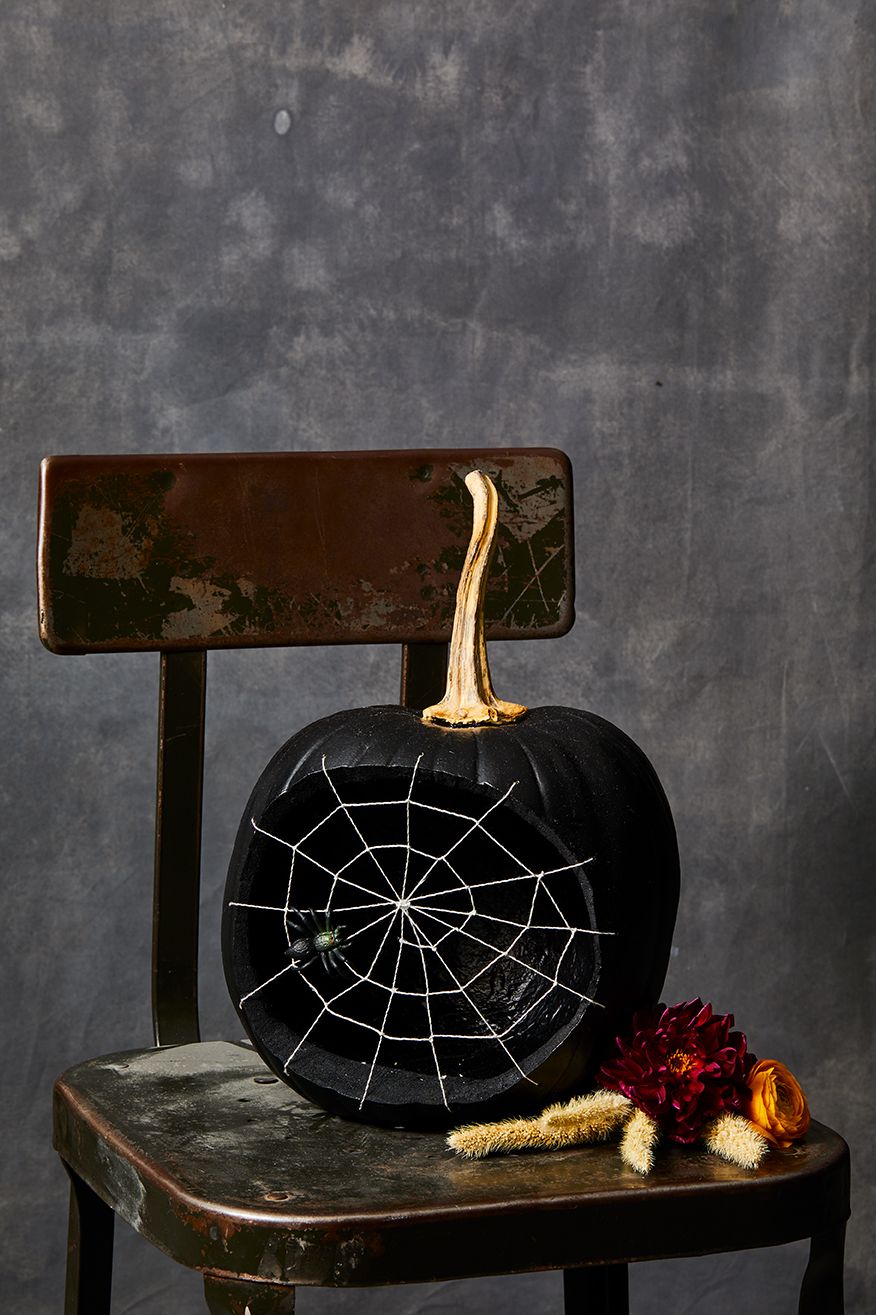pumpkin carving ideas, black pumpkin with spider web design on the front