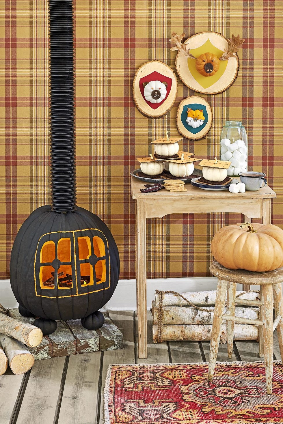 cabin scene with pumpkins styled to resemble smores, hunting trophy plaques, and a carved wood burning stove