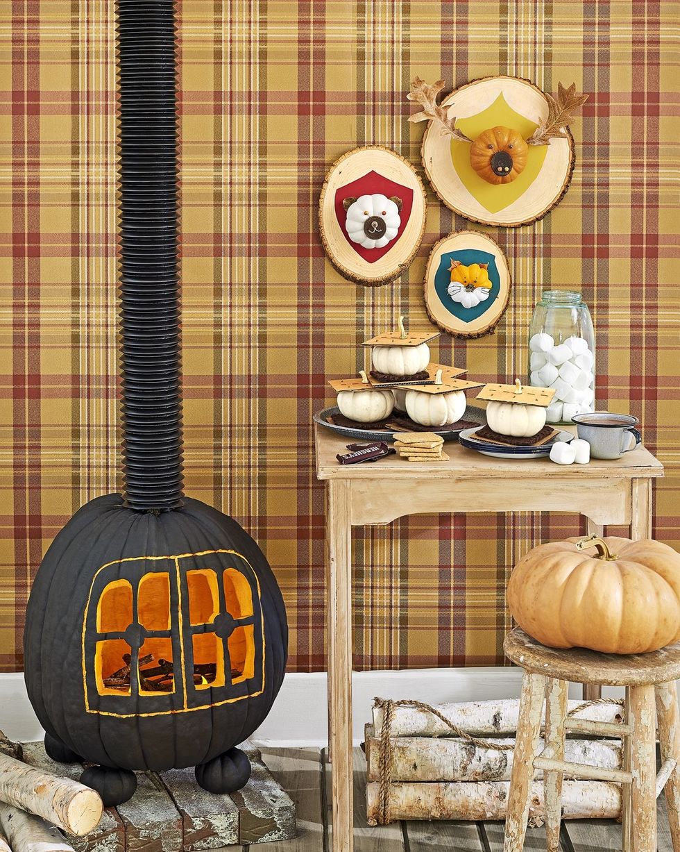 cabin scene with pumpkins styled to resemble smores, hunting trophy plaques, and a carved wood burning stove