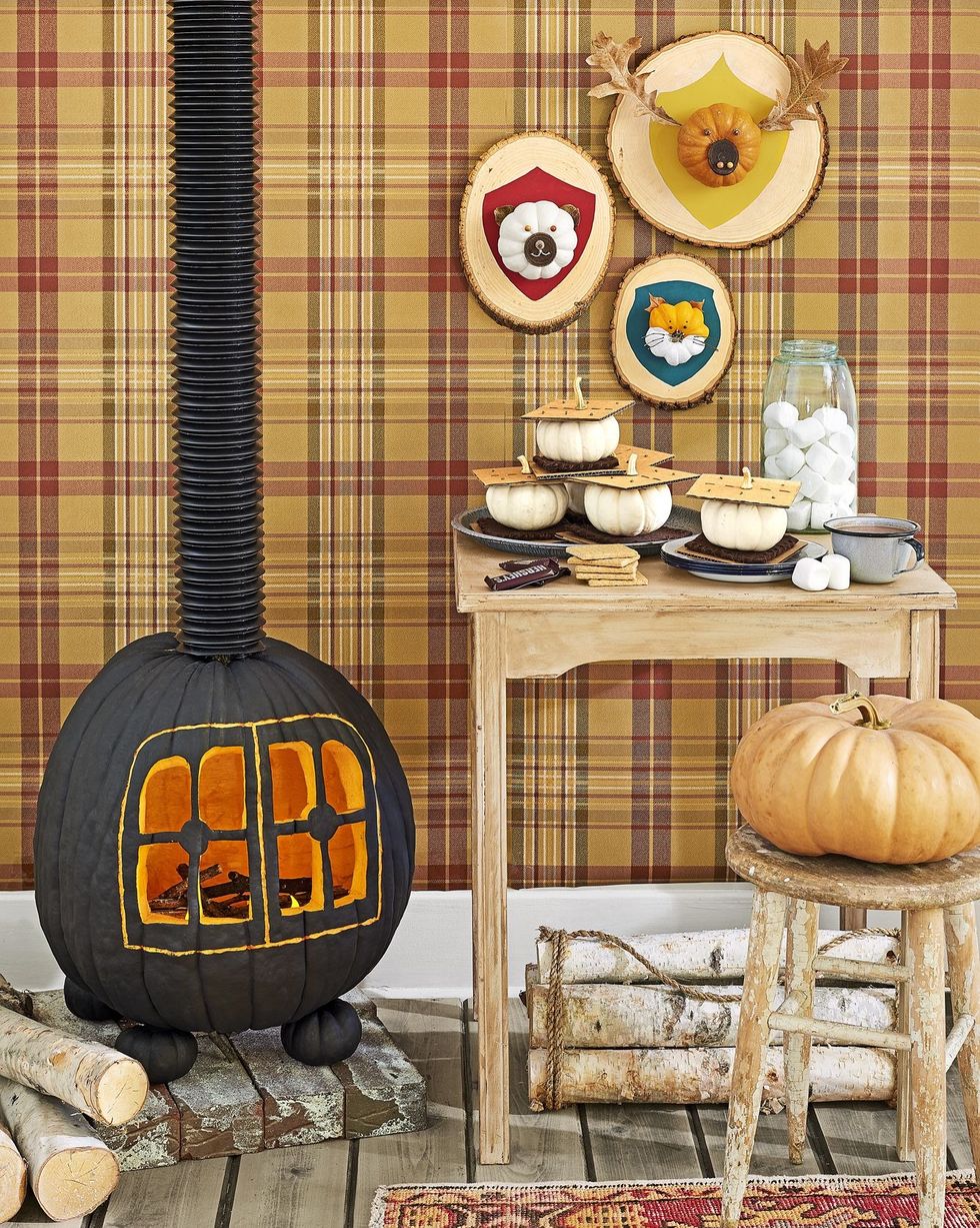 cabin scene with pumpkins styled to resemble smores, hunting trophy plaques, and a carved wood burning stove