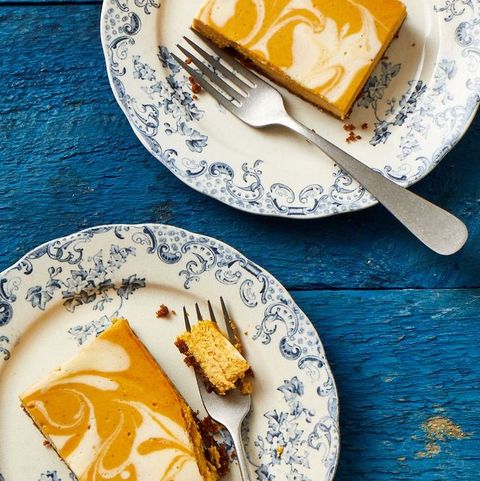 pumpkin cheesecake bars on a decorative blue and white plate with fork