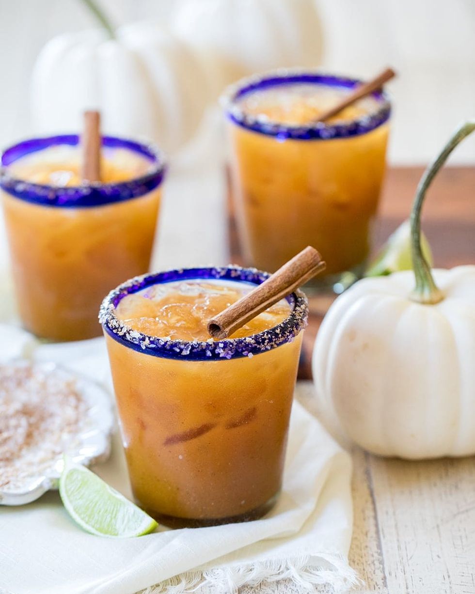 pumpkin spice margaritas with lime wedge and white pumpkin