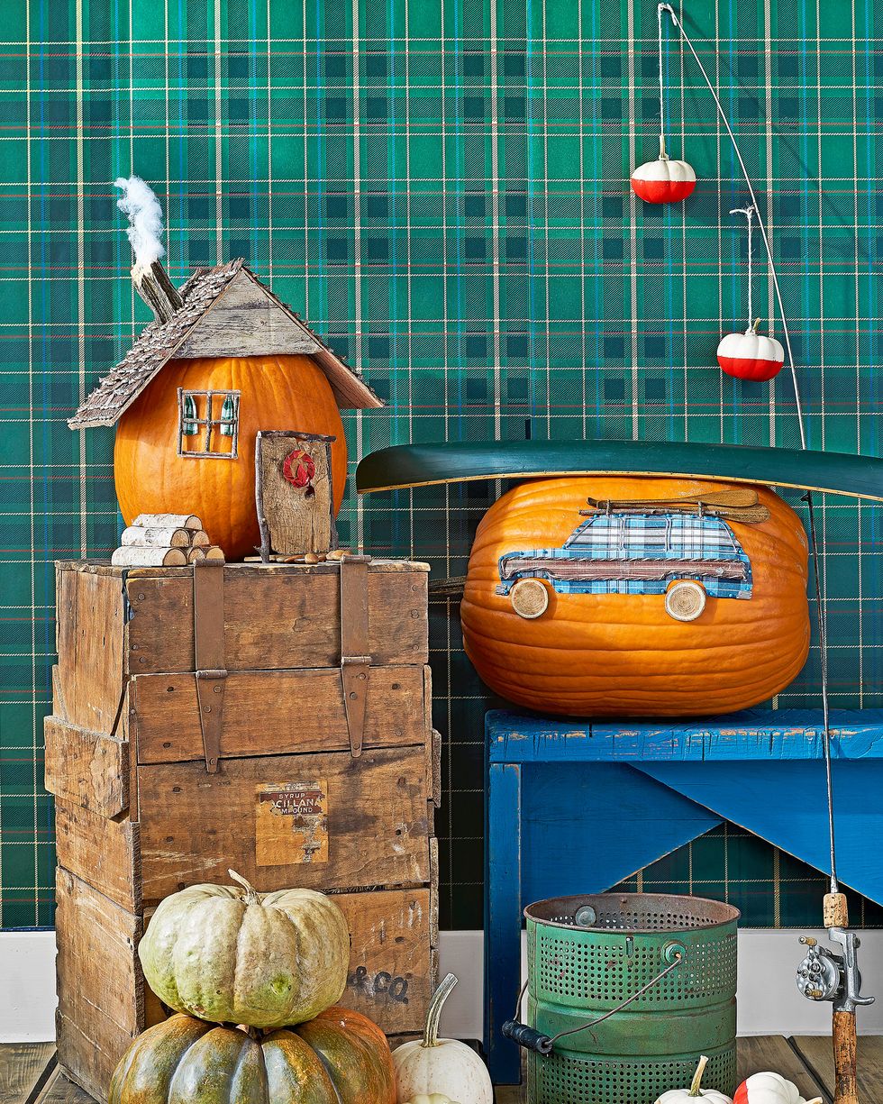 cabin, wagoneer, fishing bobs pumpkin display pictured with wood crates, rustic blue bench, fishing rod, green plaid wallpaper