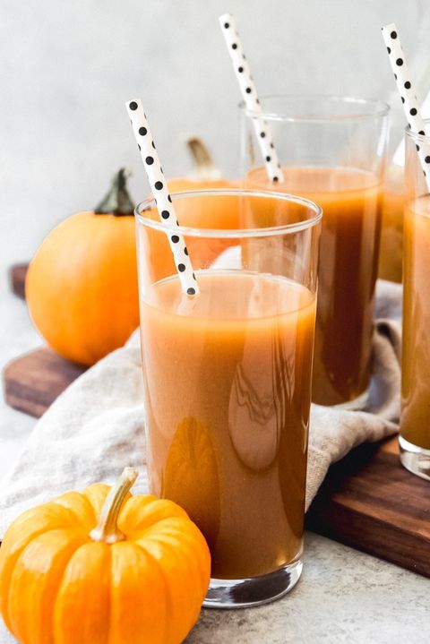 pumpkin juice with black and white straw and pumpkins