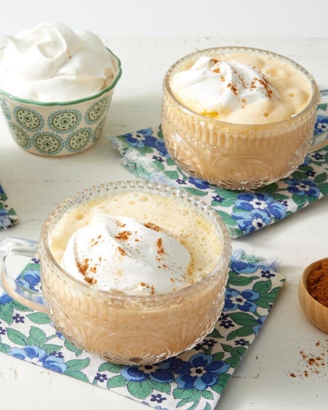 pumpkin spice latte in glass mug with whipped cream