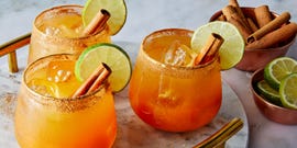 pumpkin margaritas garnished with cinnamon stick and lime wheel