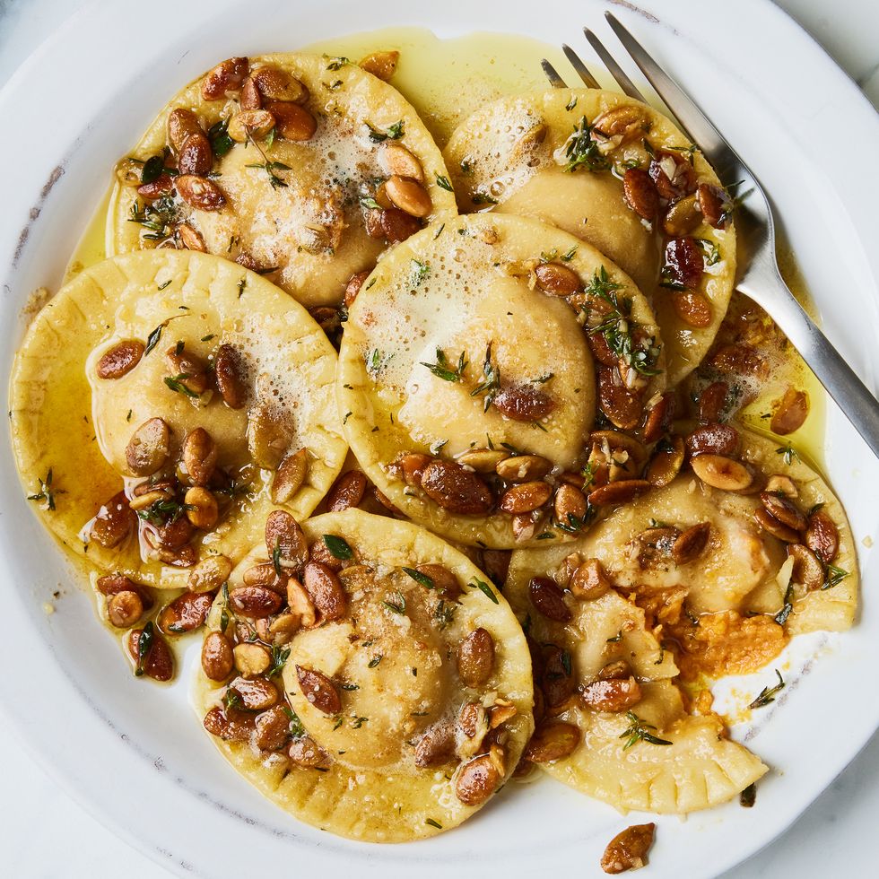 pumpkin ravioli in a brown butter sauce and topped with pumpkin seeds and thyme