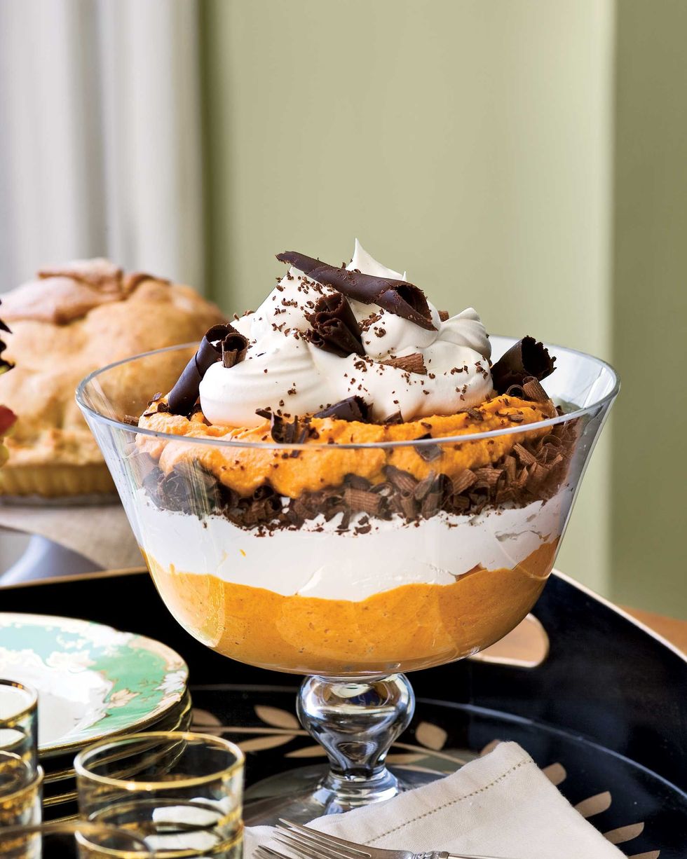 pumpkin mousse trifle in a trifle dish n a wooden serving tray with plates and napkins and forks