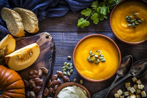pumpkin soup with ingredients on rustic wooden table