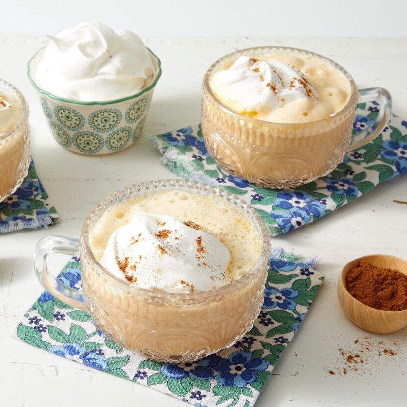 pumpkin spice latte recipe with whipped cream and pumpkin spice on blue floral napkins