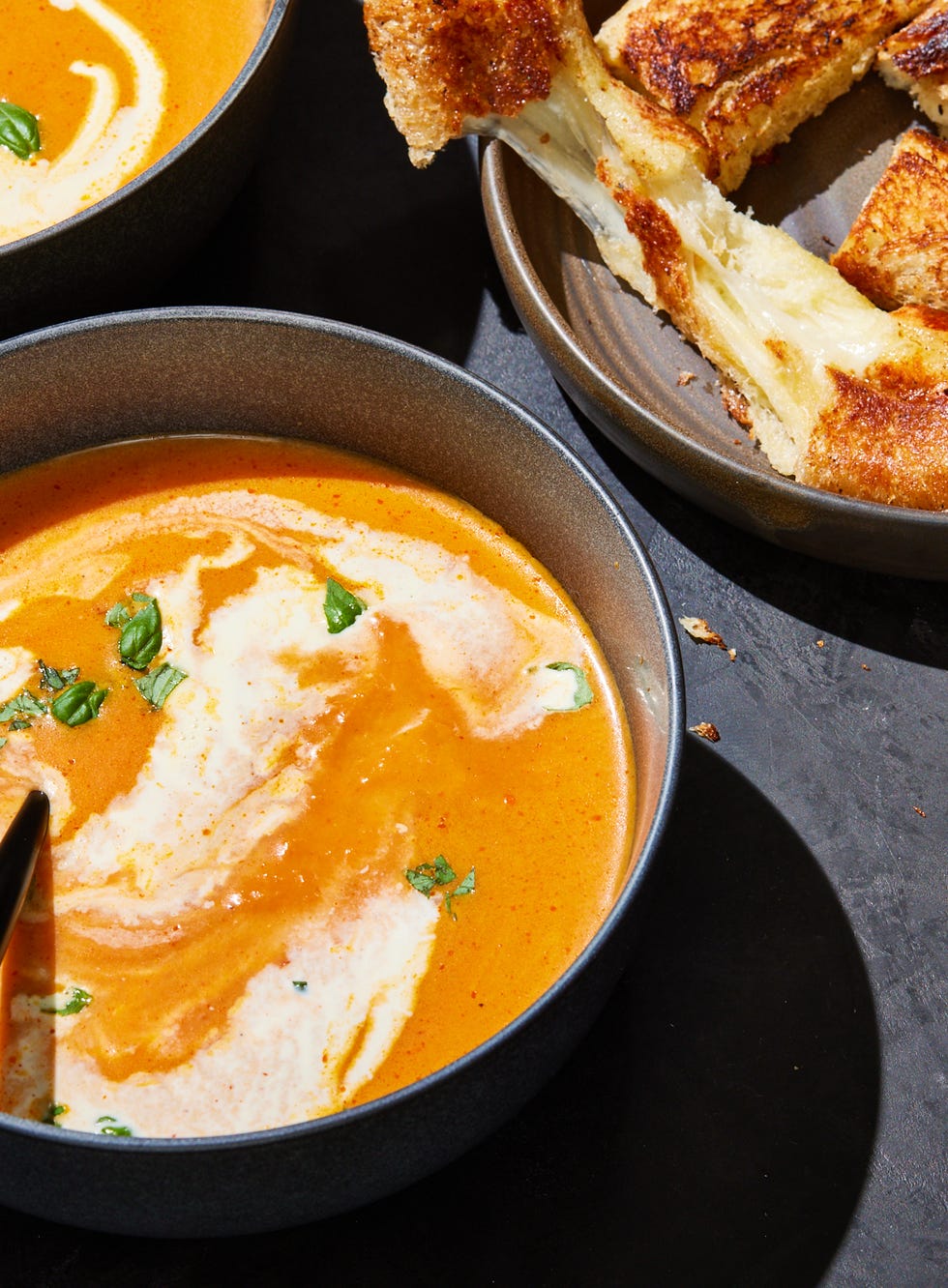 pumpkin tomato soup with cream and herbs served with grilled cheese sticks
