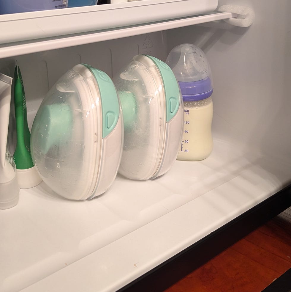 Wearable breast pumps and a bottle in a mini fridge wearable breast pumps and a baby bottle of breastmilk in a mini fridge