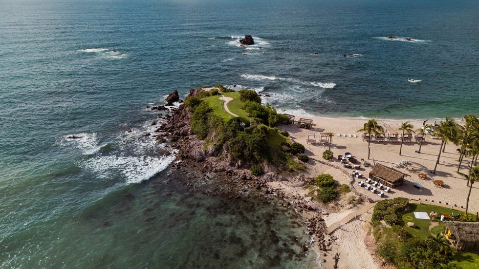 secluded beach landscape with a rocky outcrop and lush greenery