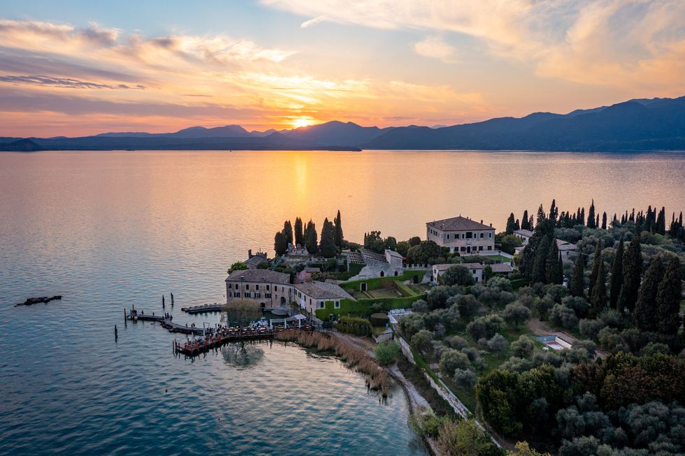 punta san vigilio at sunset, aerial view east coast of garda lake in springtime