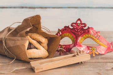 purim jewish holiday composition with hamantaschen, purim mask and purim gragger on a vintage wood background with copy space"r"n