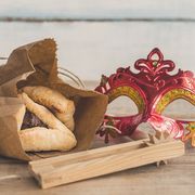 purim jewish holiday composition with hamantaschen, purim mask and purim gragger on a vintage wood background with copy space"r"n
