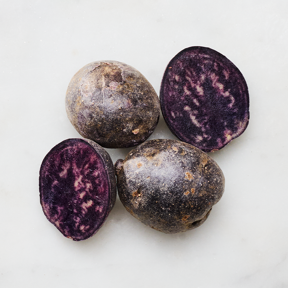 whole and halved purple potatoes