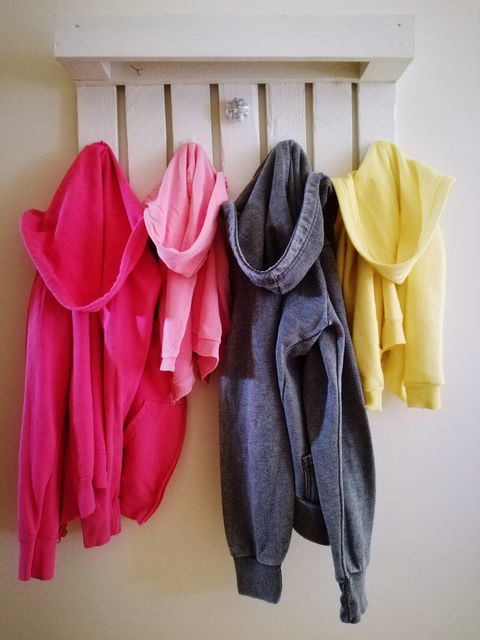 closeup of hooded jackets hanging on hooks at home