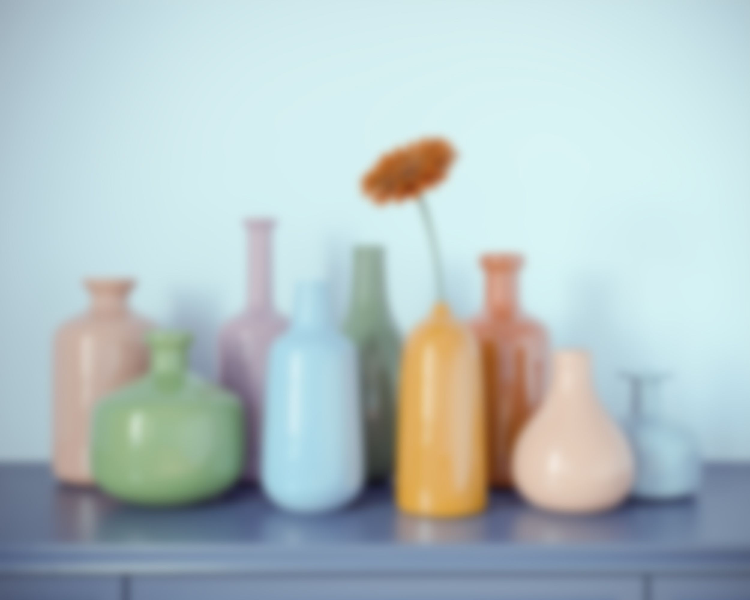 a group of glass bottles with a flower in them