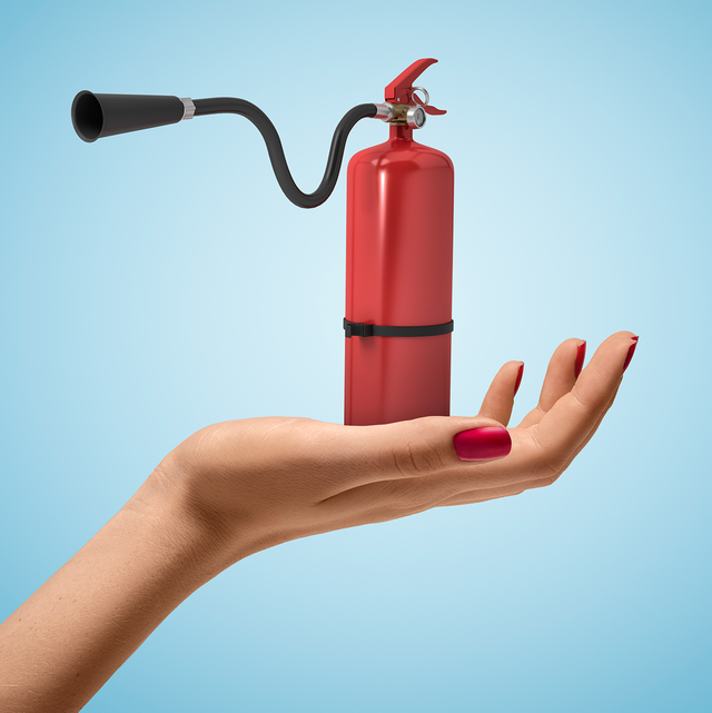 woman's hand holding tiny fire extinguisher