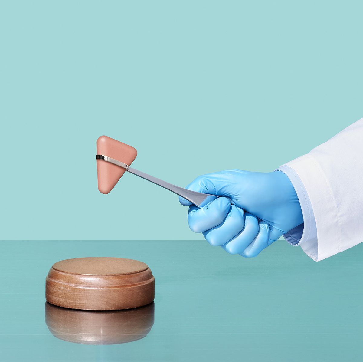 a doctor's gloved hand using medical utensil as judge's gavel