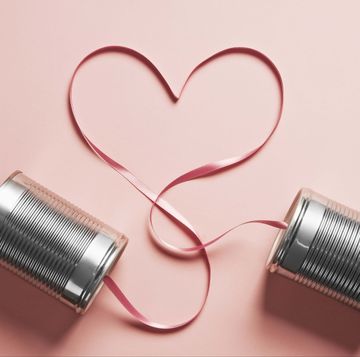 tin can telephones on a pink background with a heart shaped cord connecting them