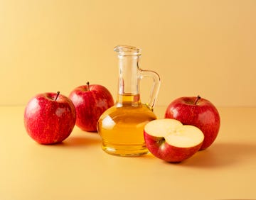 apple cider vinegar and apples on yellow background