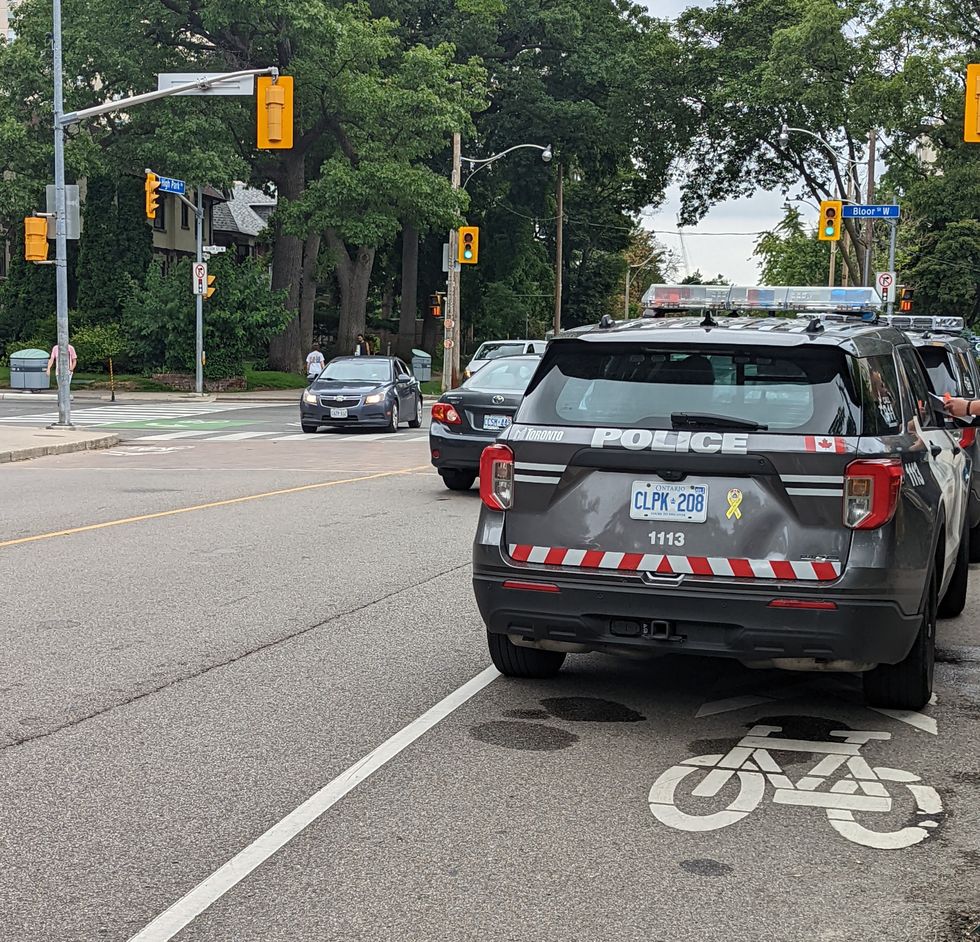 toronto police vehicles int he bike lane near bloor street one of many dangerous intersections for cyclists in the city
