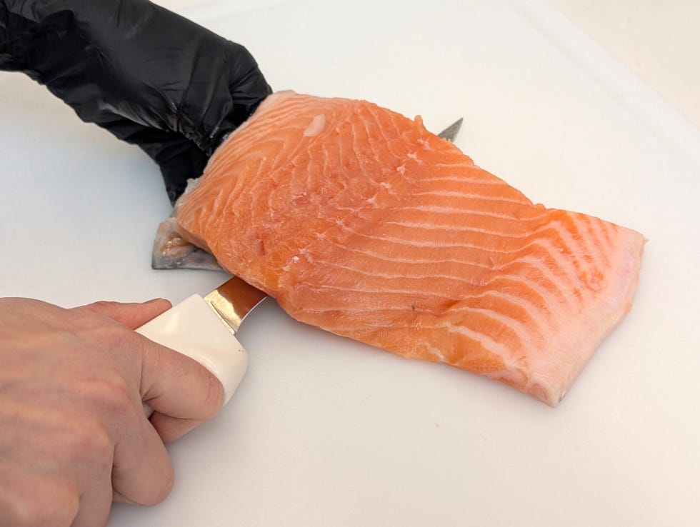 fish fillet knife used to remove skin from a piece of salmon