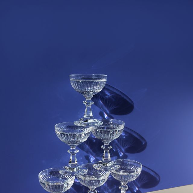 pyramid of champagne glasses with water on the beige blue background
