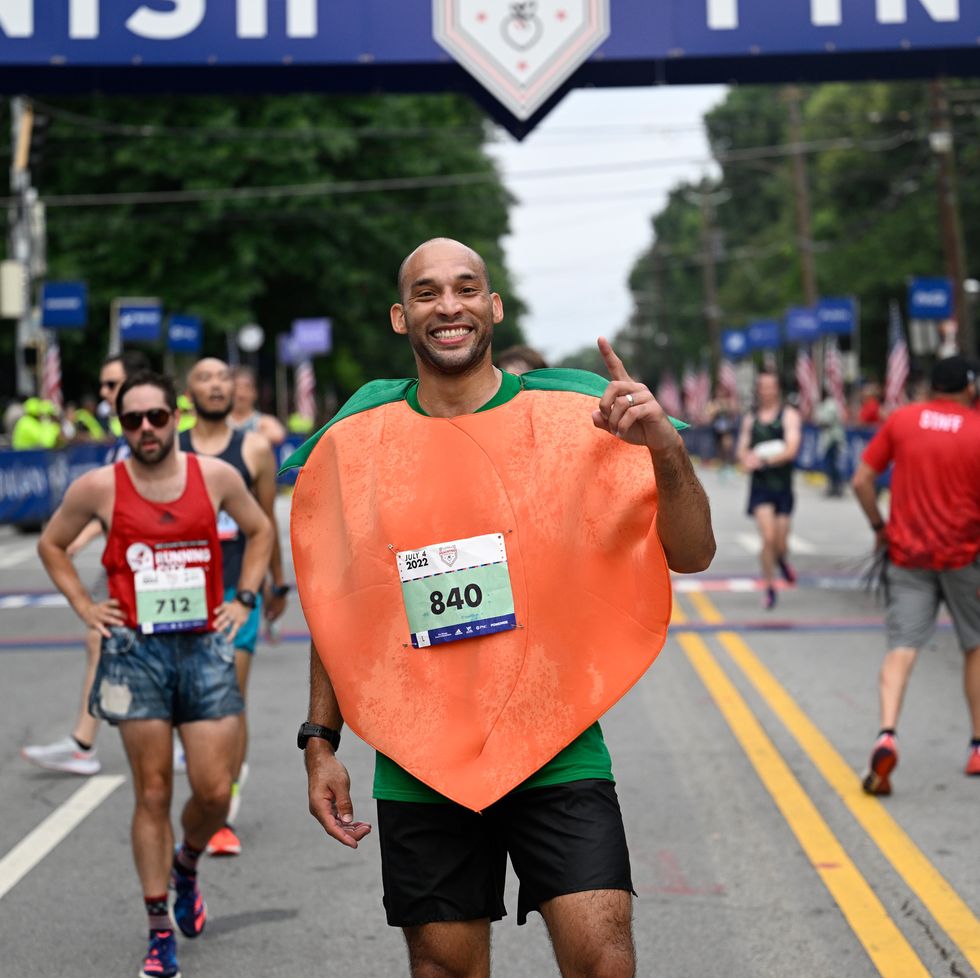 a runner in a peach costumer poses for a picture at the end of a race