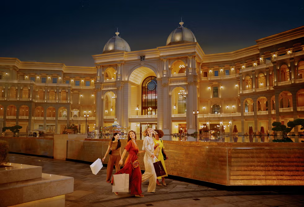 group of women walking with shopping bags in an upscale shopping area at night