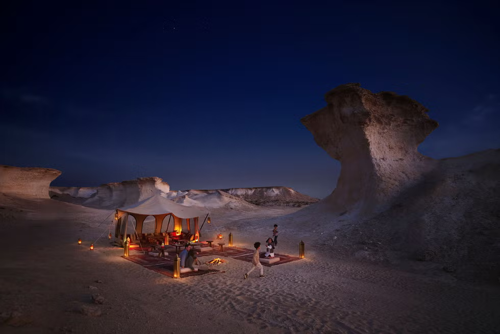 desert campsite at night with a tent and warm lighting