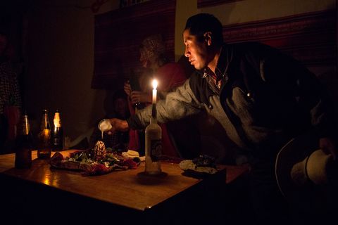 Een Quechua brengt de nacht voor de ceremonie een spiritueel offer
