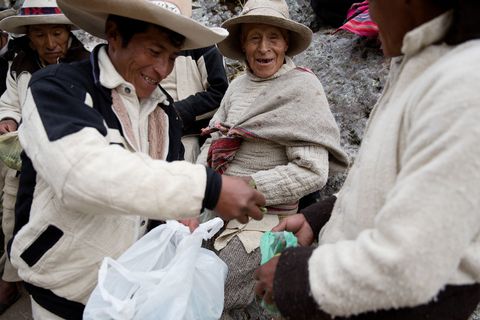 Een man deelt cocabladeren uit tijdens de ceremonie Cocabladeren spelen een belangrijke rol in de Quechuacultuur