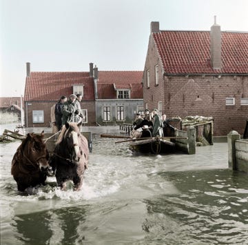 overlevenden van de watersnoodramp op paard en in een bootje