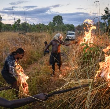 foto van aboriginals die gras in brand steken