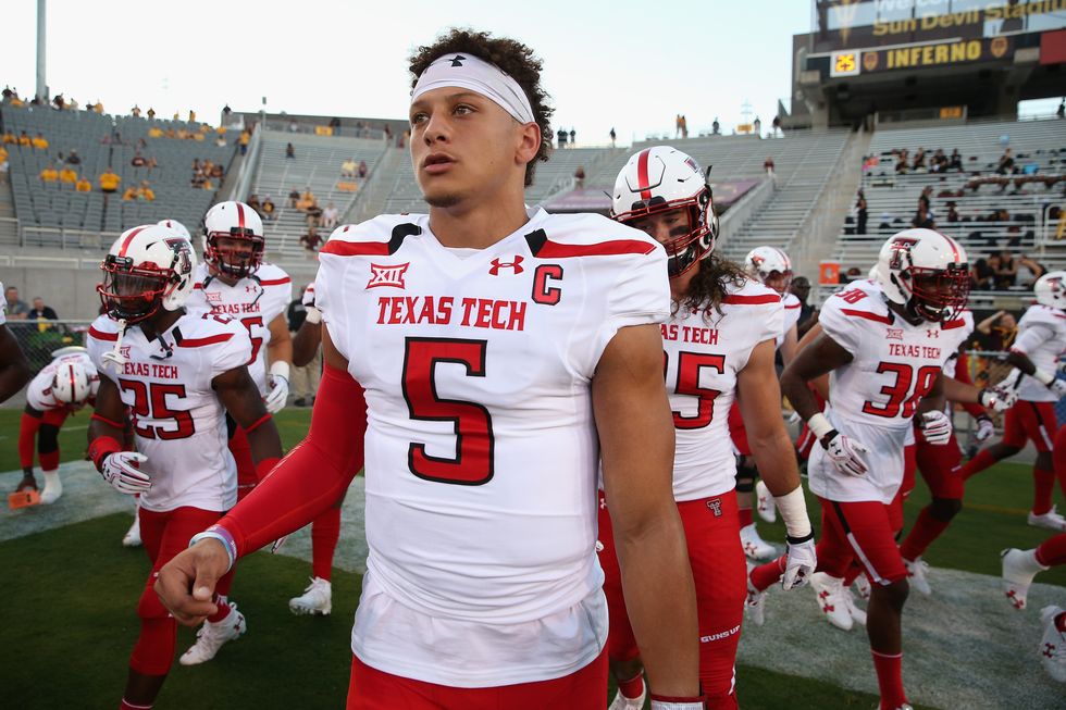 patrick mahomes wearing his texas tech uniform and surrounded by football teammates