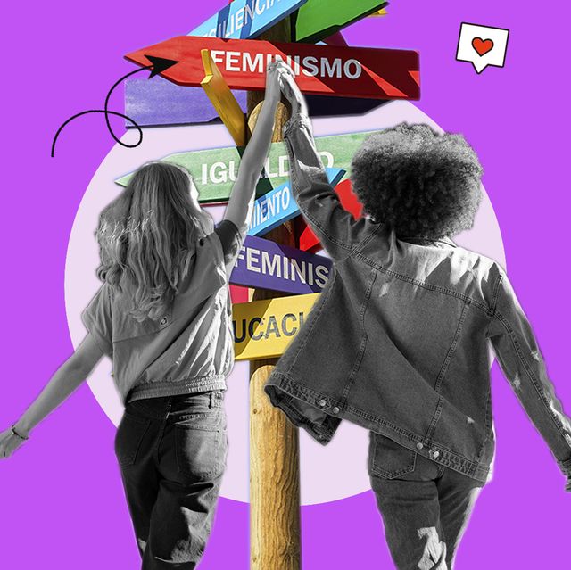 mujeres caminando de la mano hacia un poste con carteles feministas