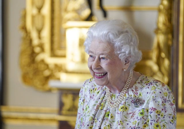 Queen Elizabeth Glows in a Floral Dress While Admiring Fine China