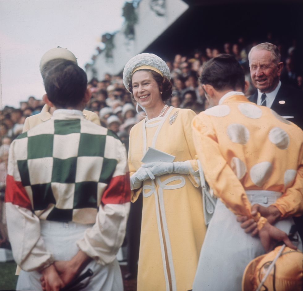 Queen Elizabeth II chats with jockeys Ron Quinton and Hilton Cope before the Queen Elizabeth Stakes at Randwick racecourse near Sydney, during her tour of Australia on April 1, 1970