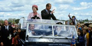 Queen Elizabeth ll and Prince Philip wave to well-wishers from their open car in October 1981 in Wellington, New Zealand