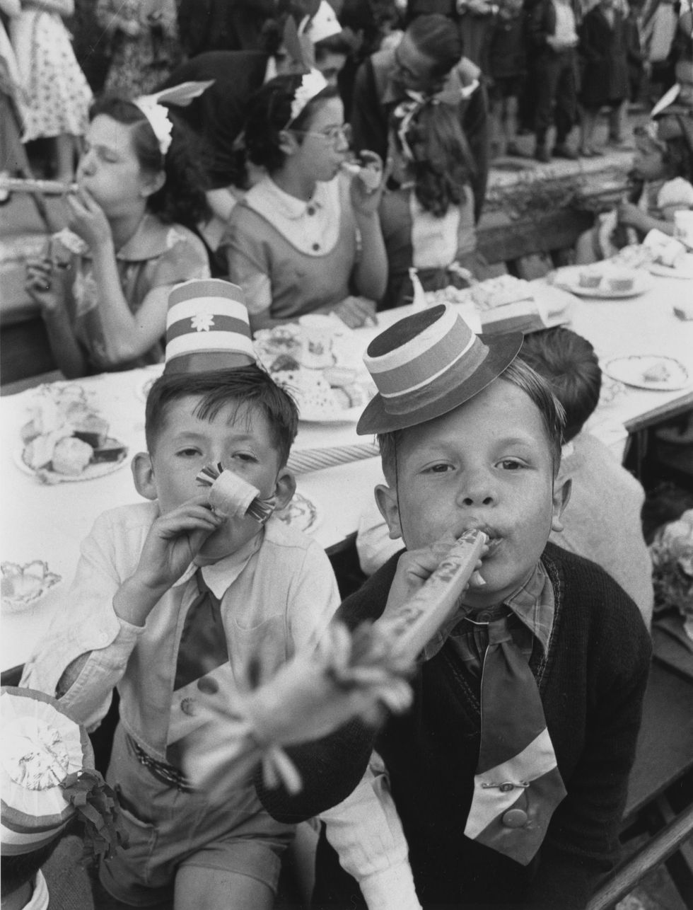 young boys blowing paper whistles at a street party held in morpeth street, london, during queen elizabeth ii's coronation celebration